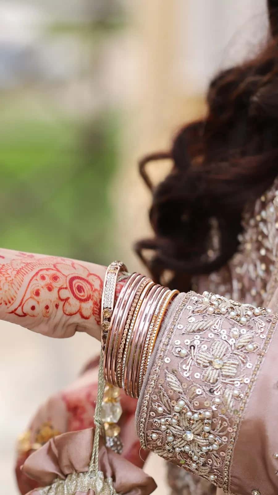 The groom slipping a ring onto the bride's hennaed hand
