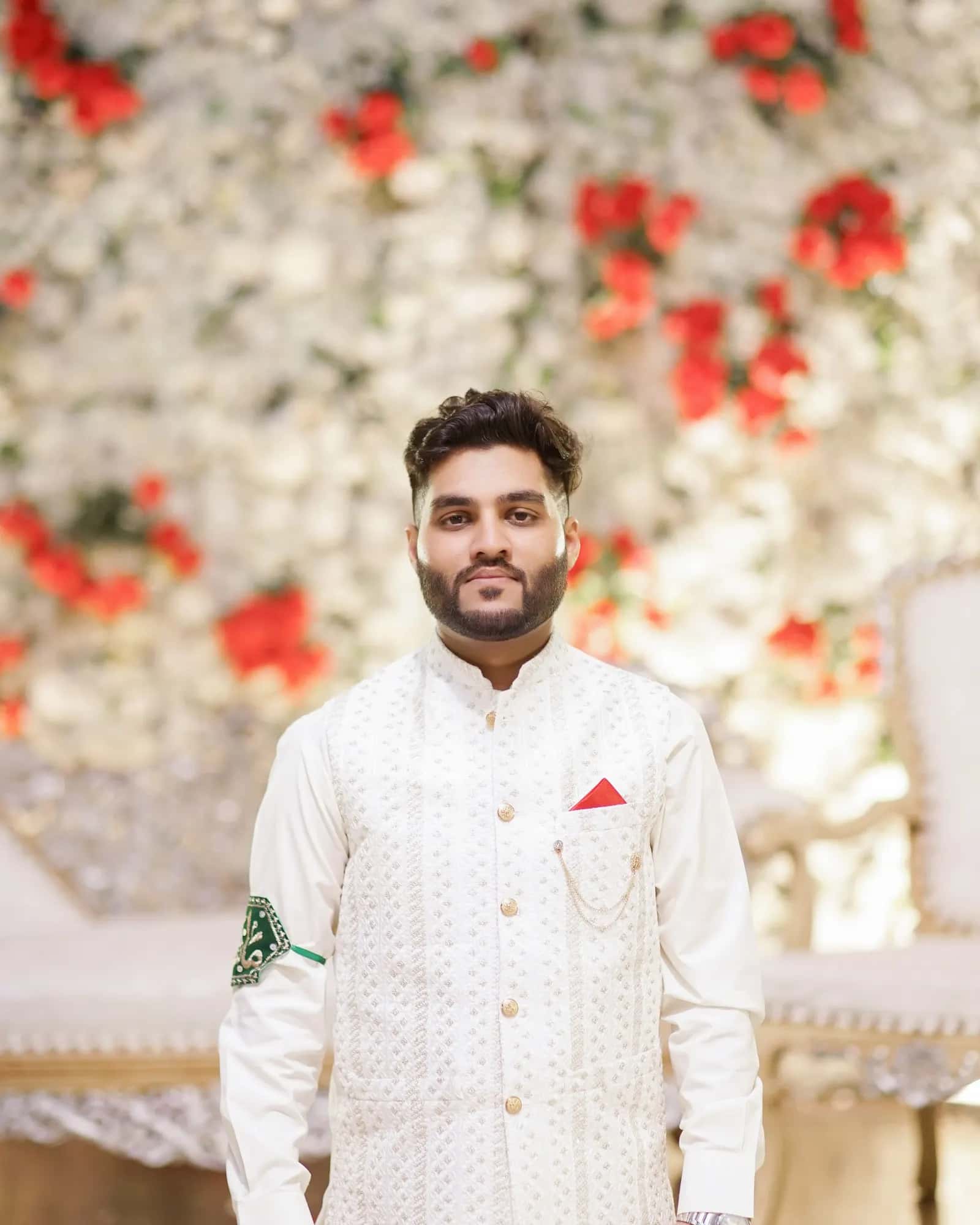 A groom in a black and gold sherwani and turban