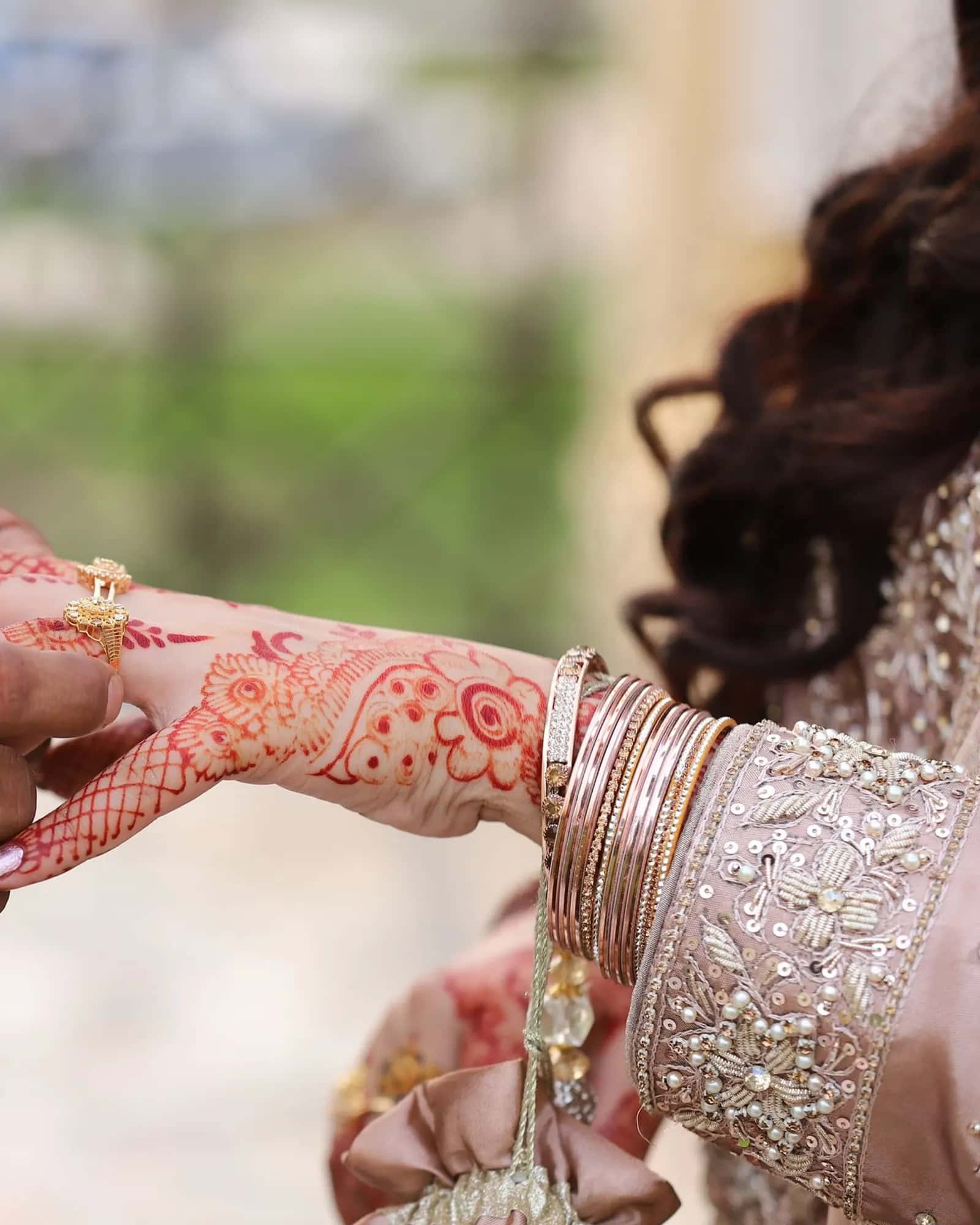 A groom in a rose garland signing the nikah papers