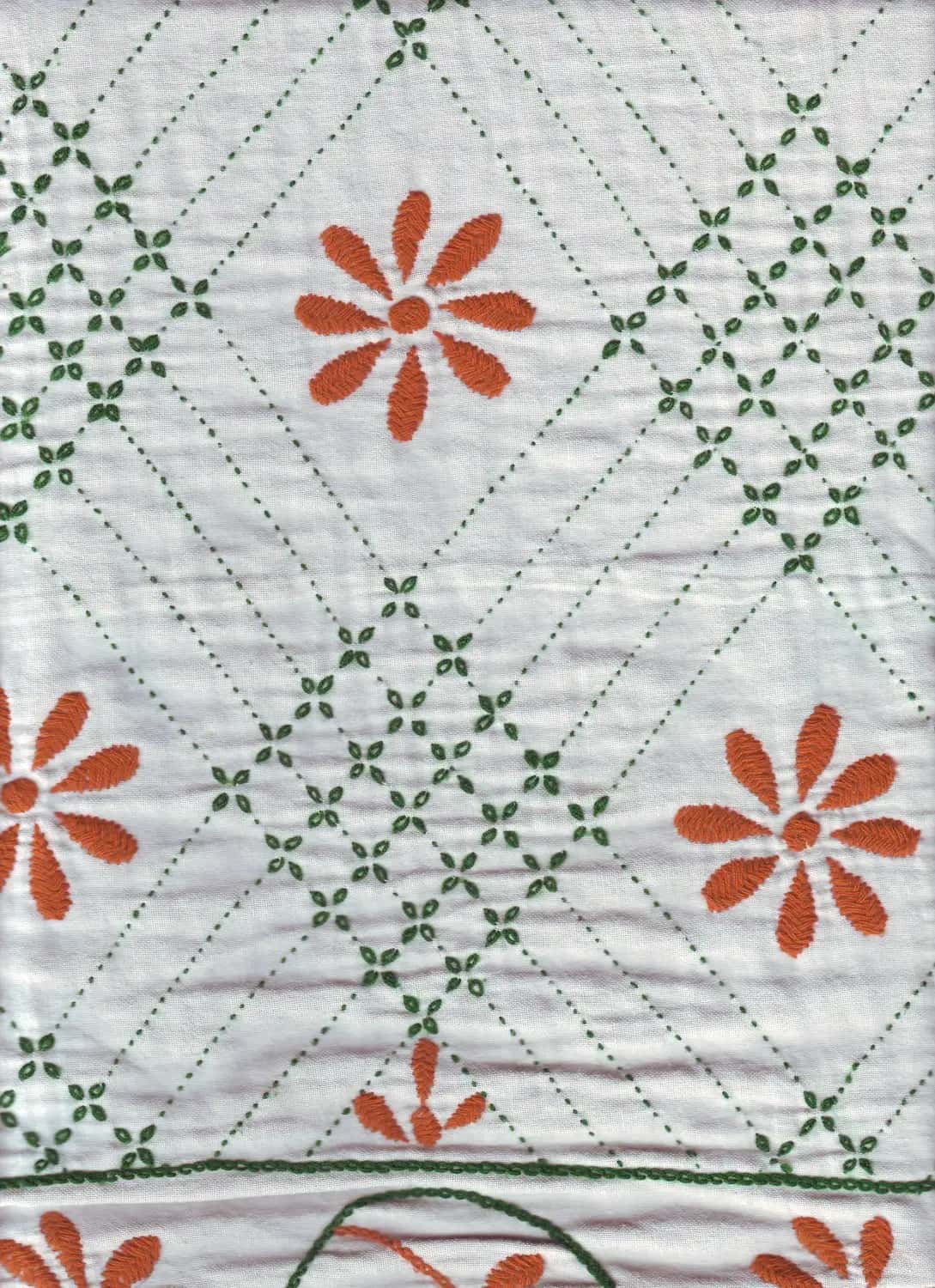 A white nakshi kantha quilt stitched with orange flowers between rows of green diamond stitching