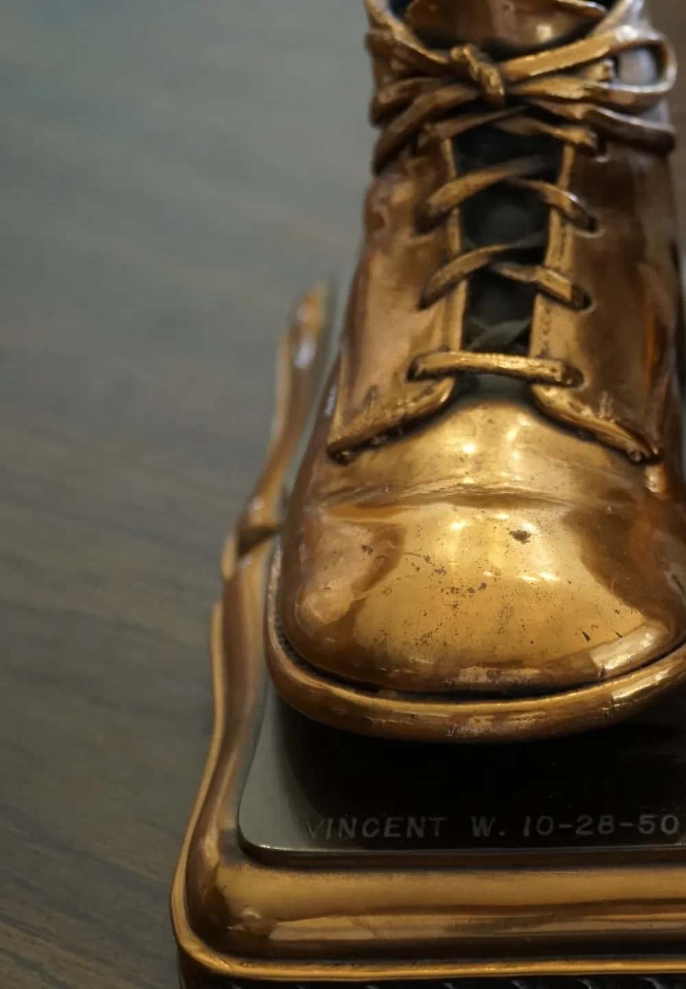 One bronzed baby shoe, laced, on its stand