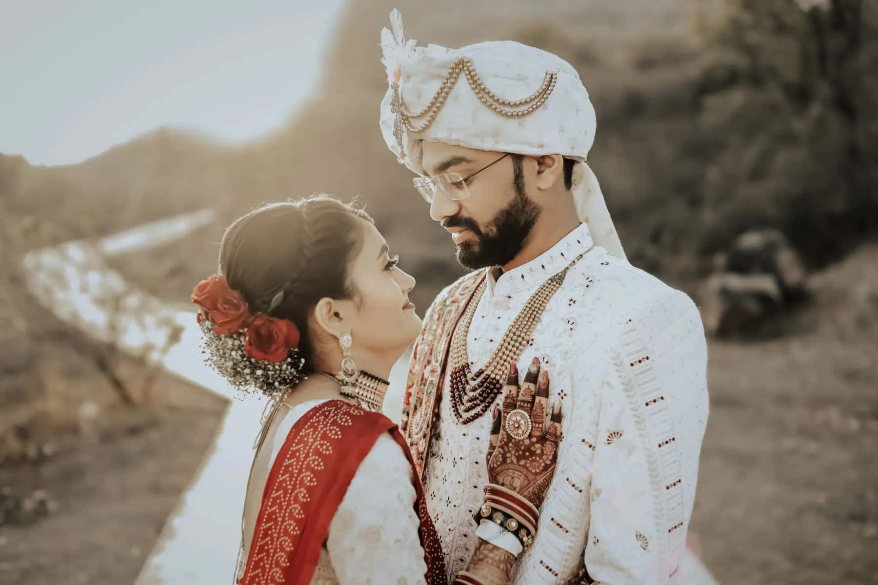 The groom in a turban and his bride face to face on a hillside