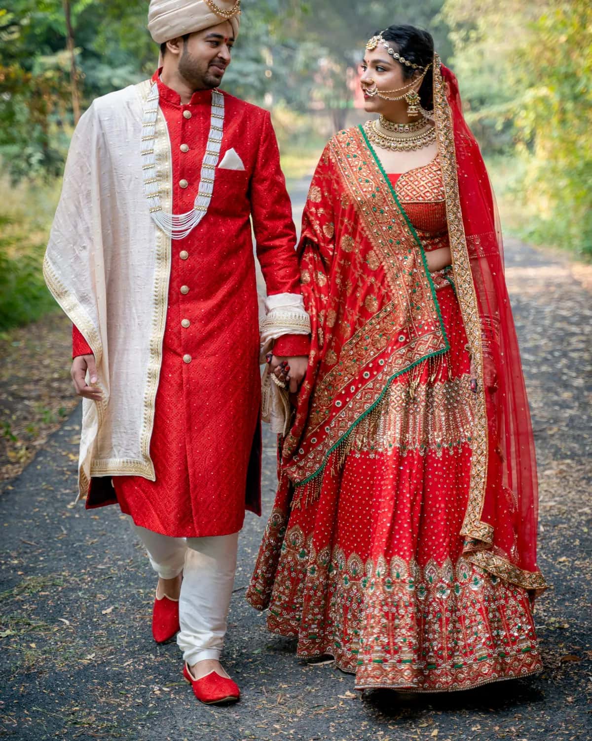 The couple walking down a leafy path in red