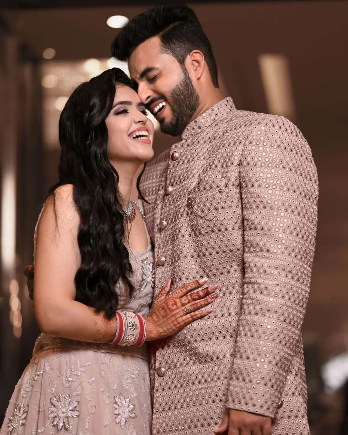 The couple in blush, her hand on his chest
