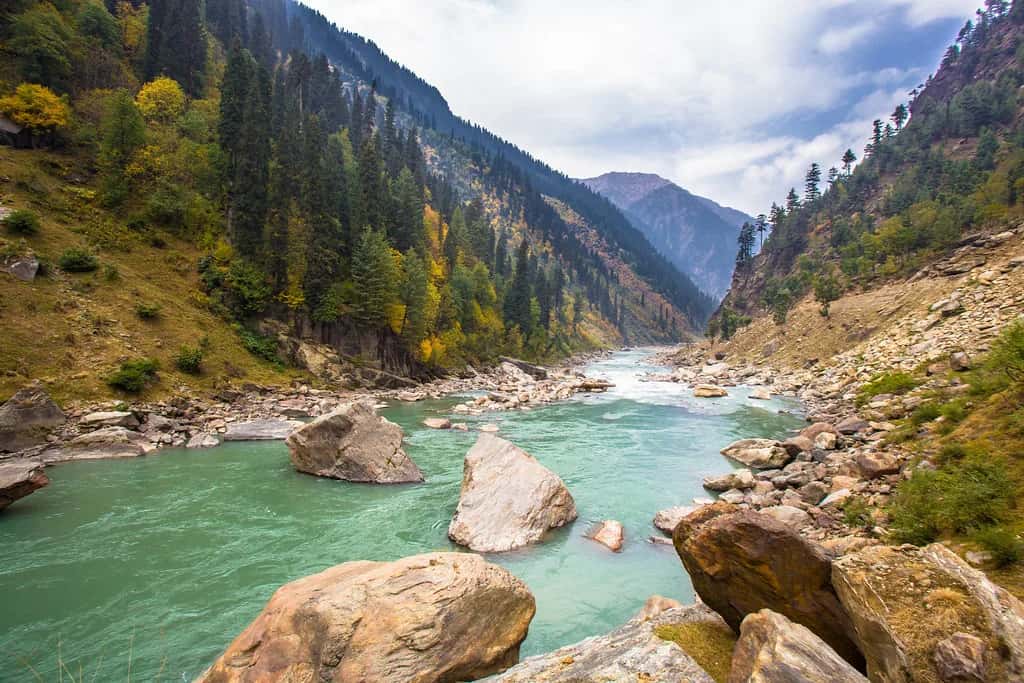 The turquoise Neelum river running between grey boulders