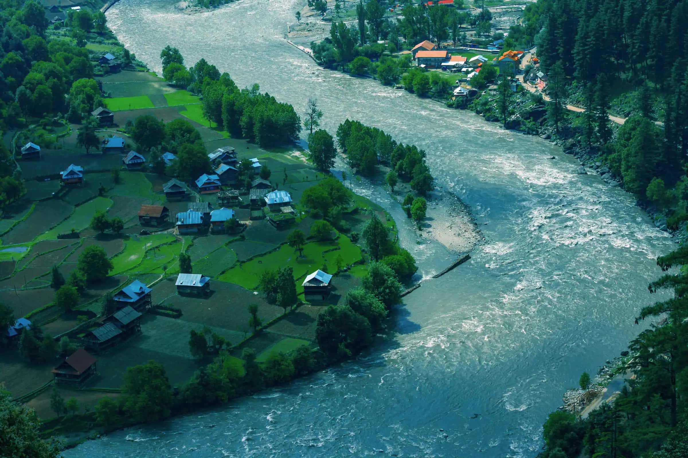 The green Neelum river bending past the village of Keran, its fields and houses on the bank