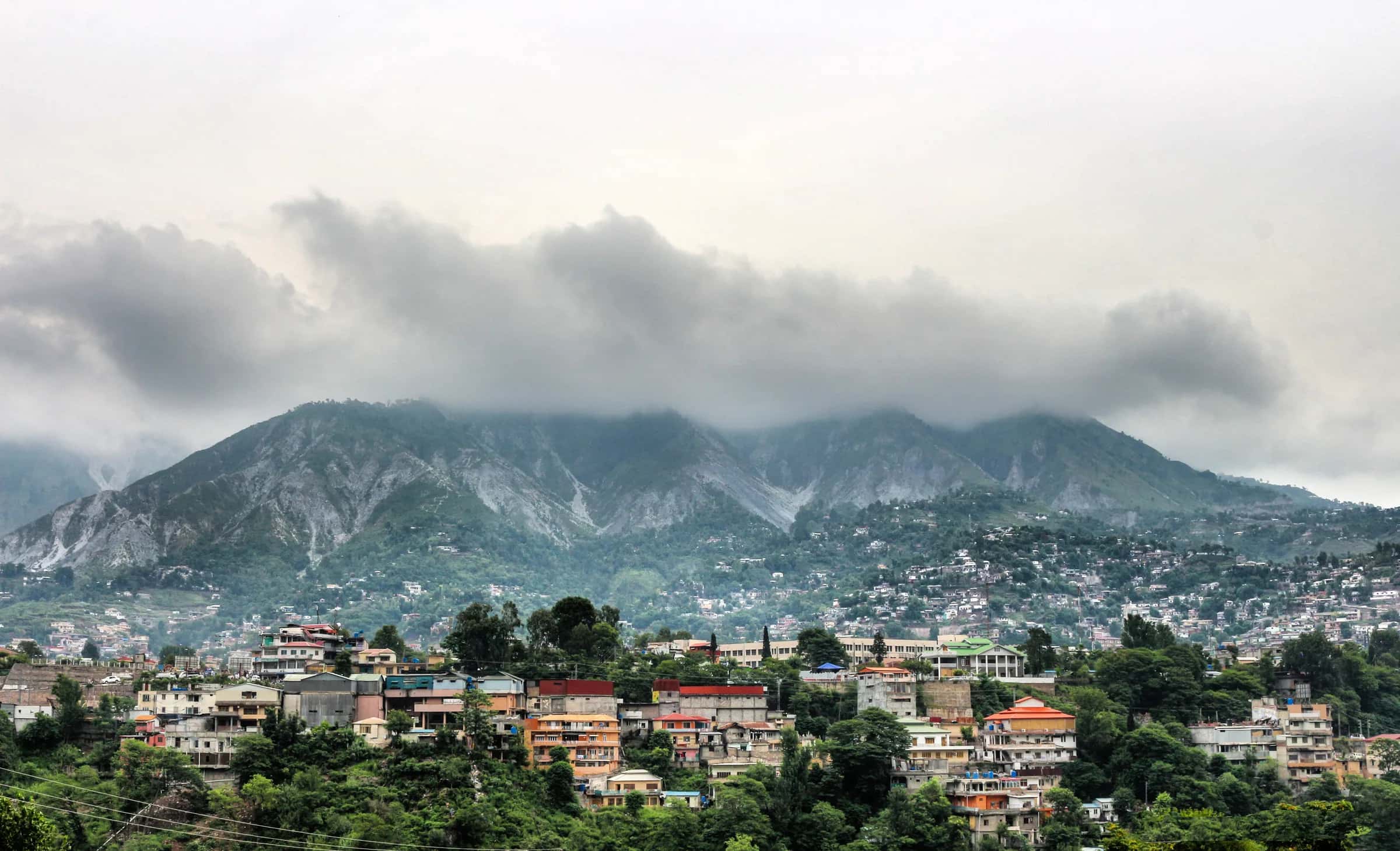 Muzaffarabad spread along its valley under a low grey sky, the hills behind it in cloud