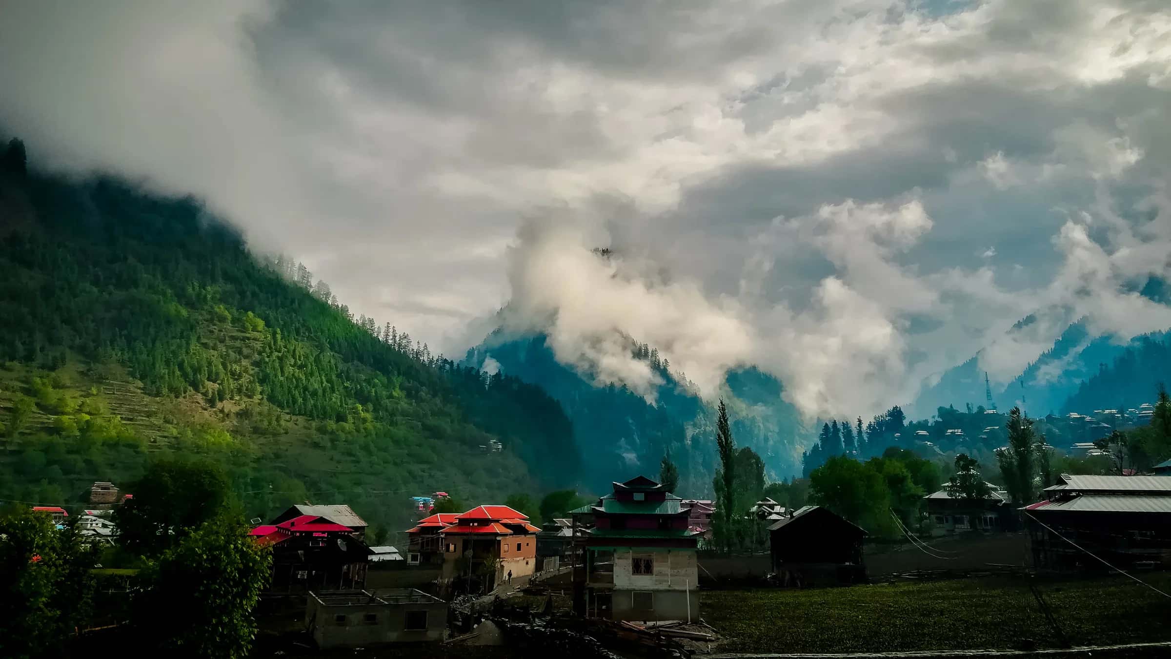 Cloud sitting on the pine ridge above the rooftops of Sharda
