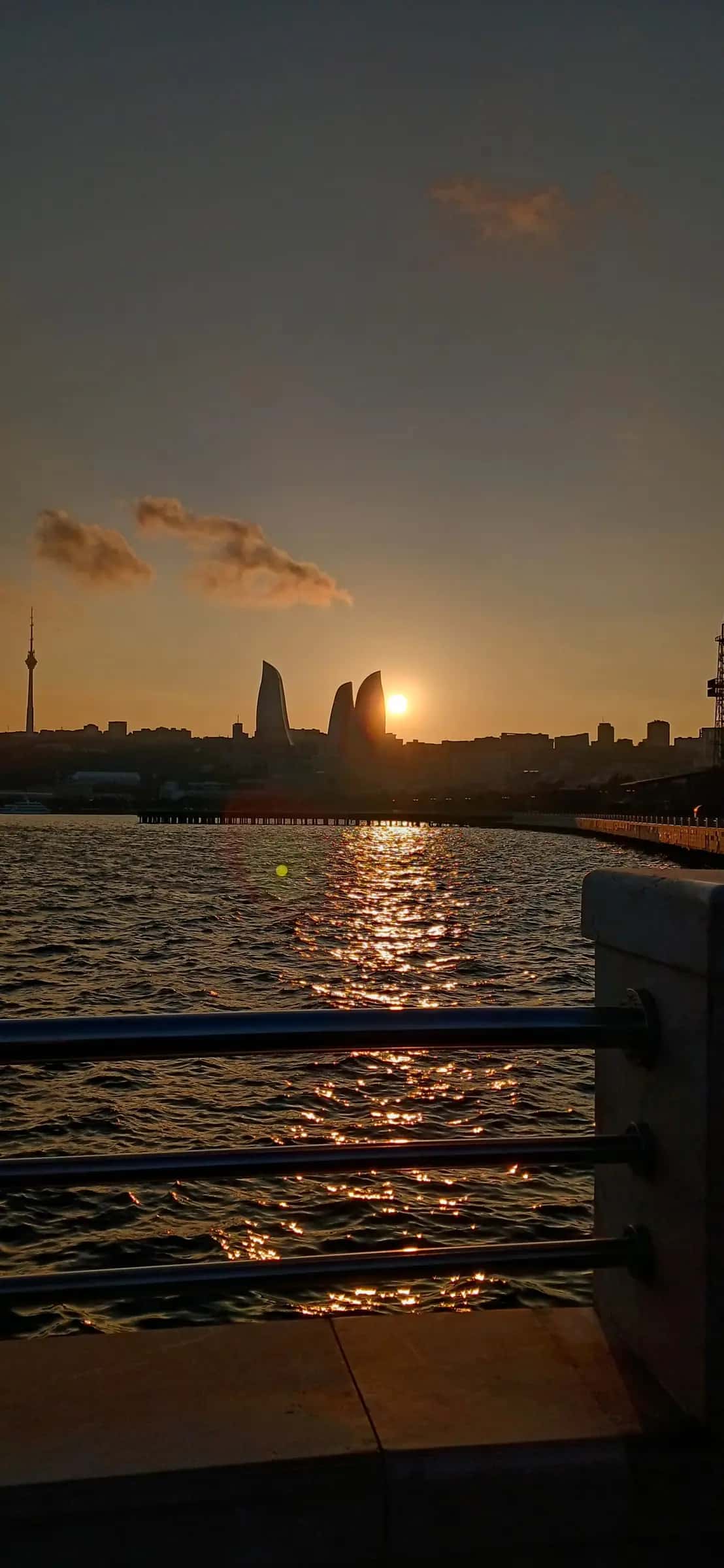 The sun going down behind the Flame Towers over the Caspian