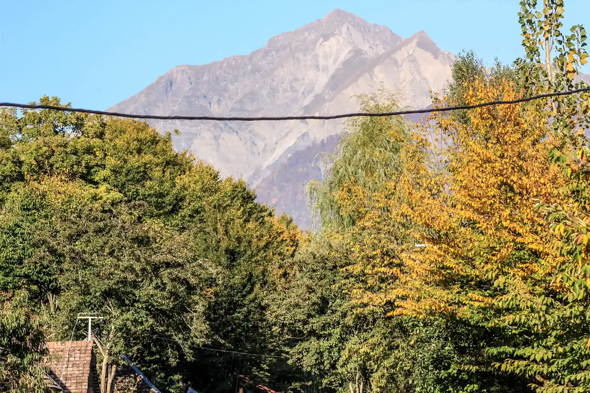 Autumn trees below the bare peak of Tufandag above Gabala
