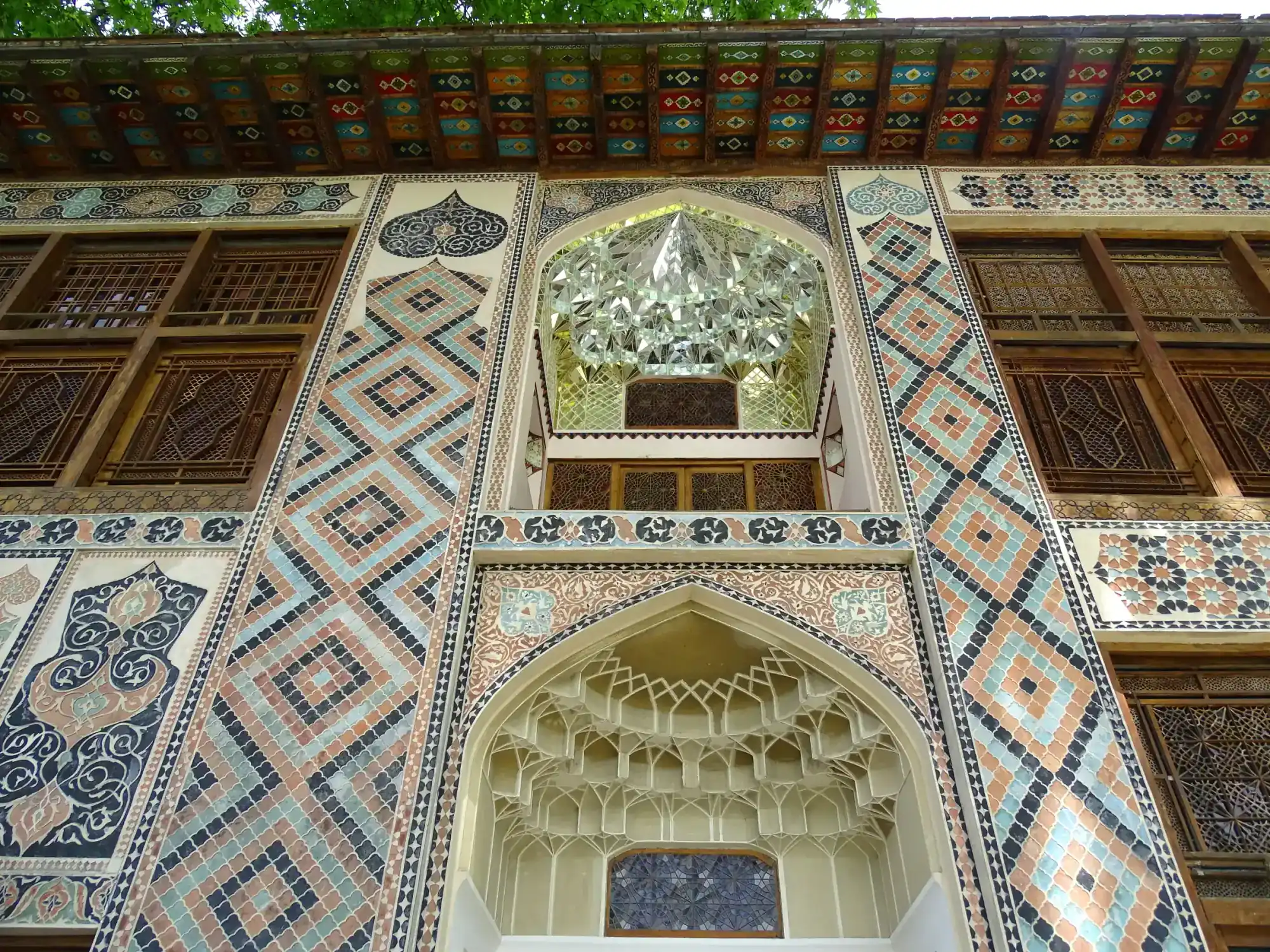 The tiled and painted facade of the Khan's palace in Sheki, its windows of coloured glass