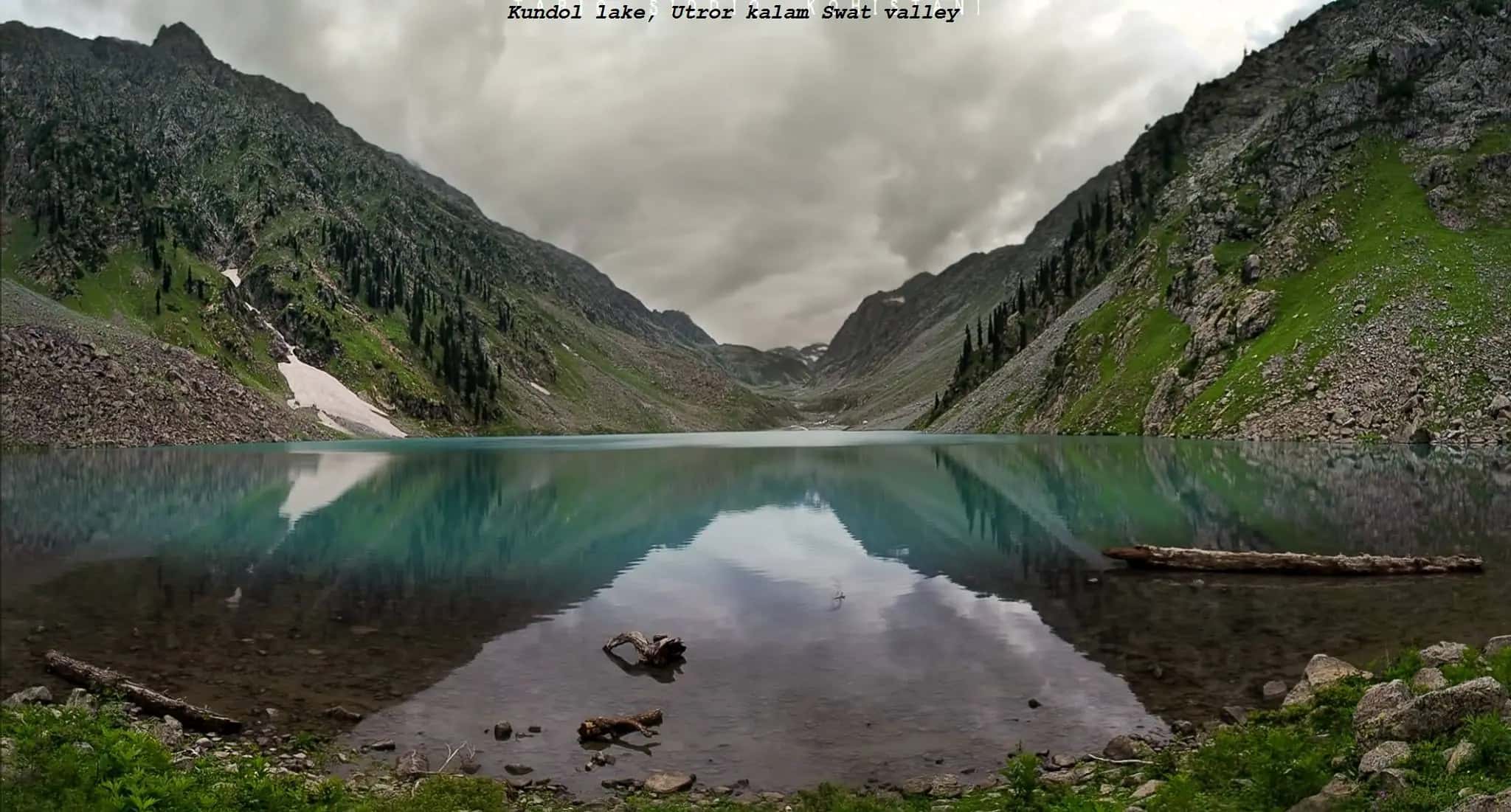 Kundol lake mirrored between steep green mountains