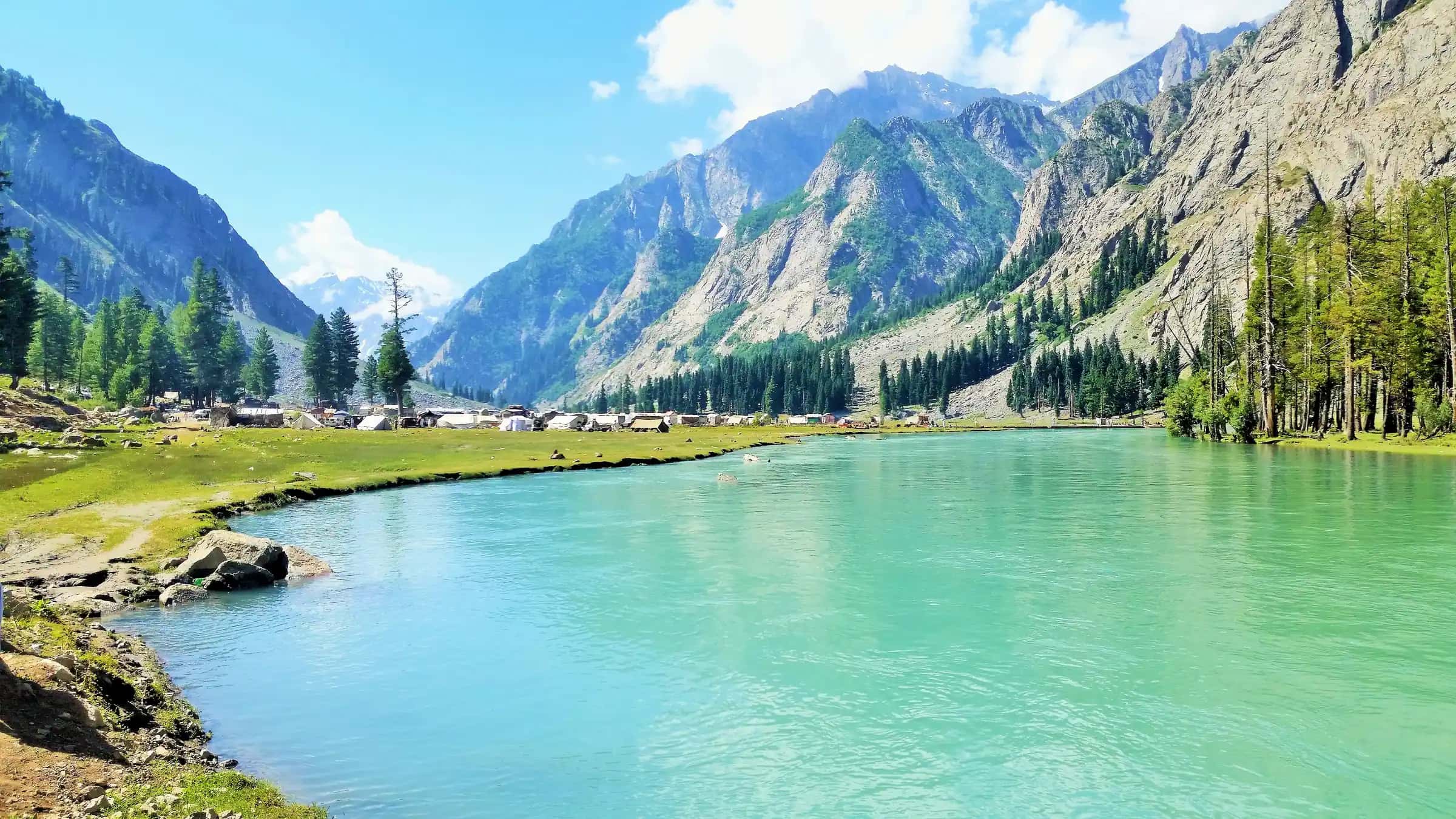 Mahodand lake, bright turquoise below forested slopes and rocky peaks