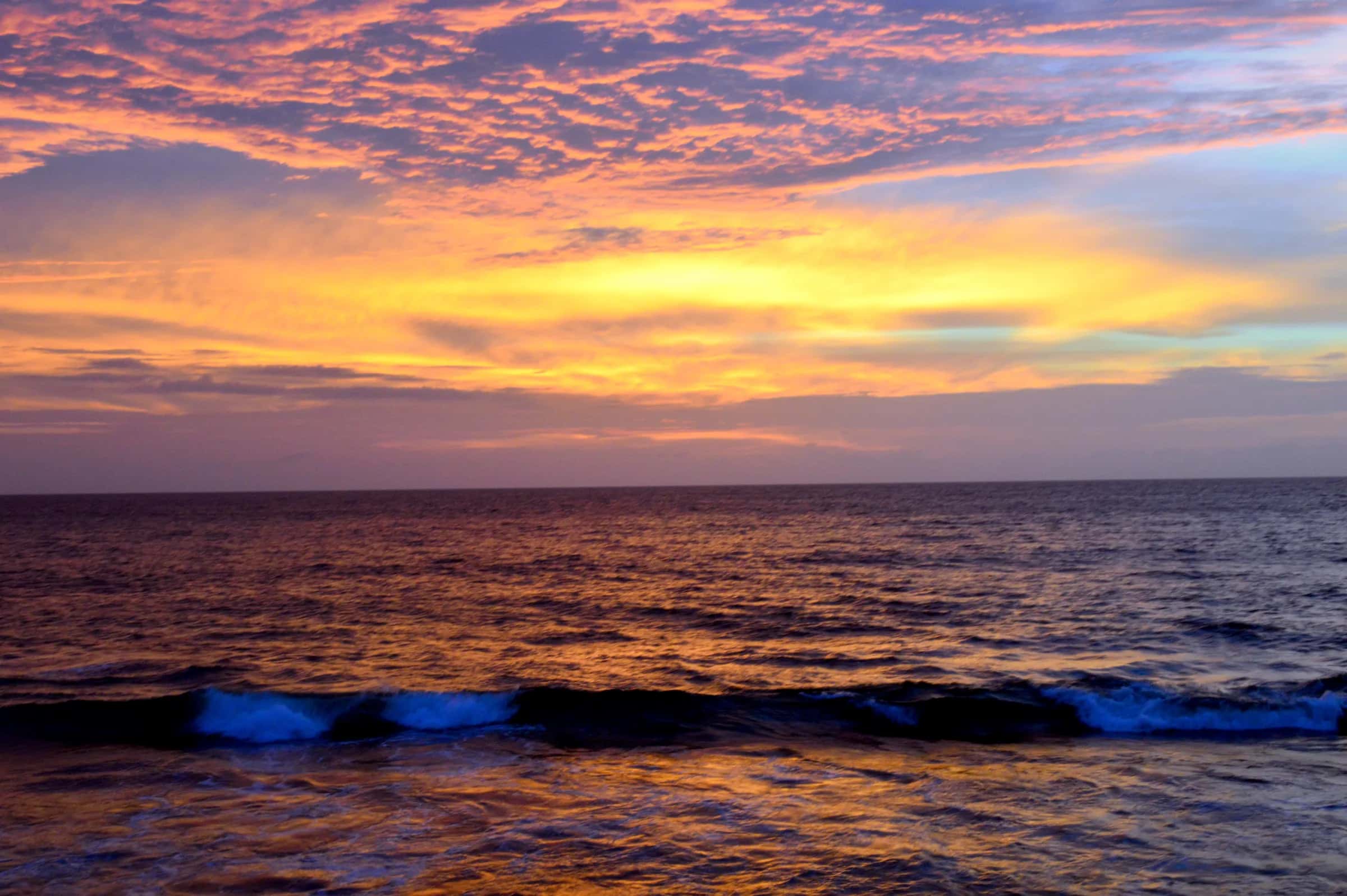 The sun setting into the sea off Galle Face, Colombo, in orange and gold