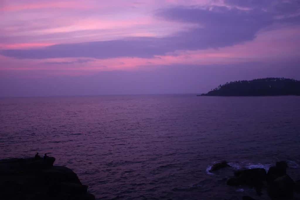 A violet dusk over the bay at Mirissa, the headland dark against the sea