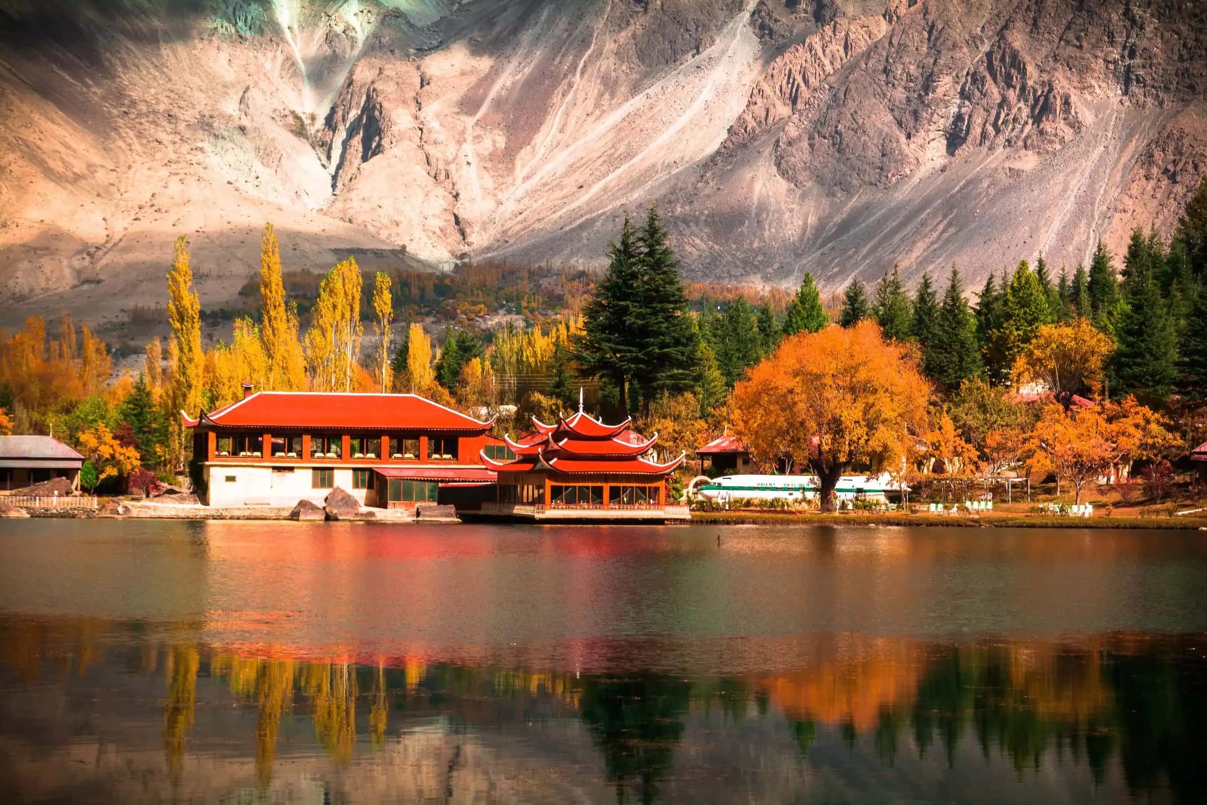 A red-roofed pavilion over the lake at Shangrila in autumn