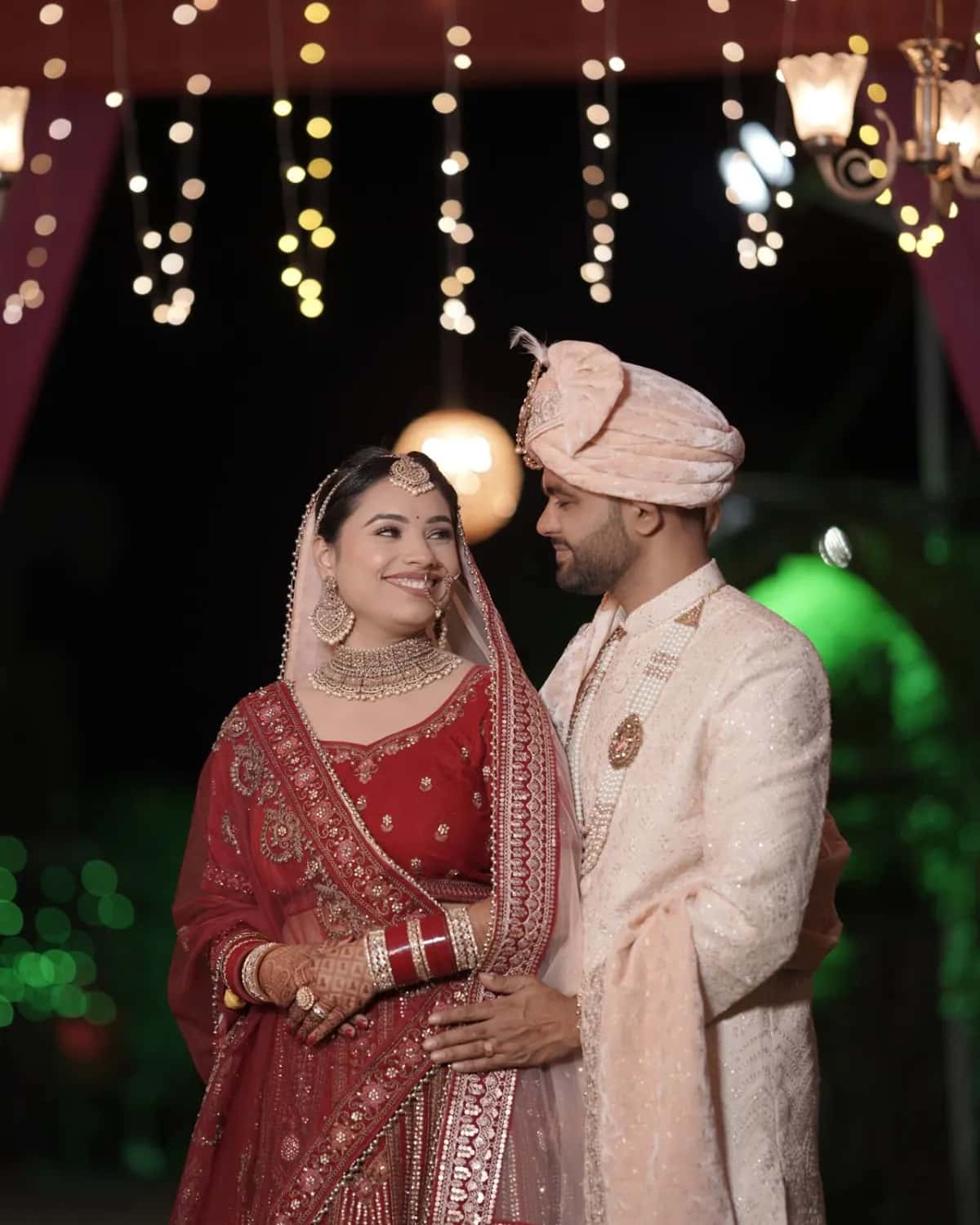The couple together under strings of warm lights