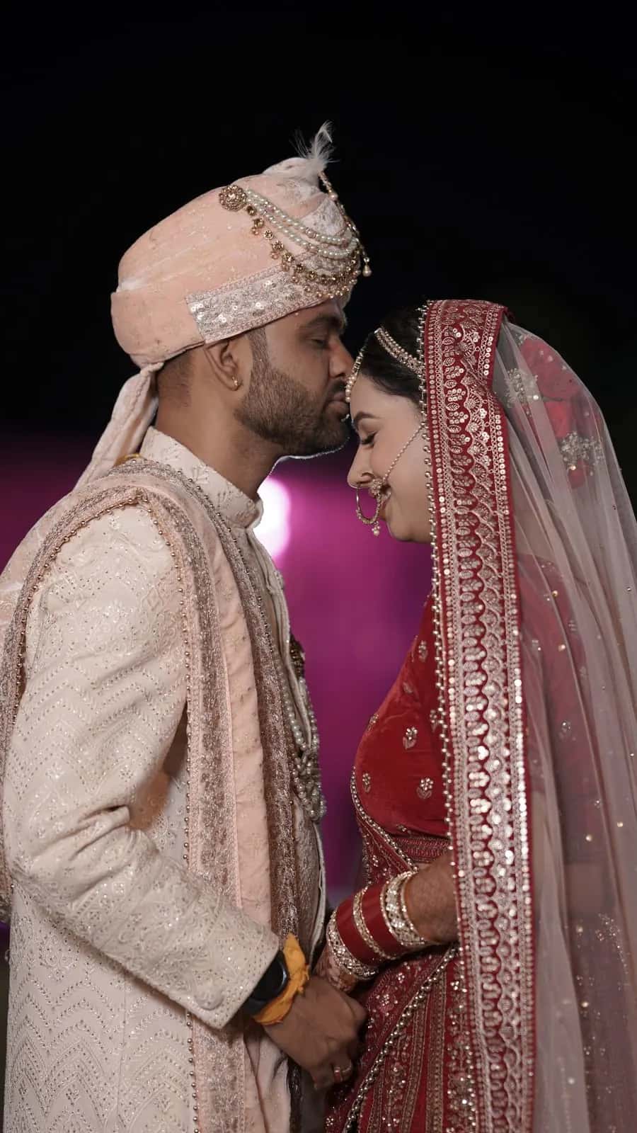 The groom touching his forehead to his bride's at night