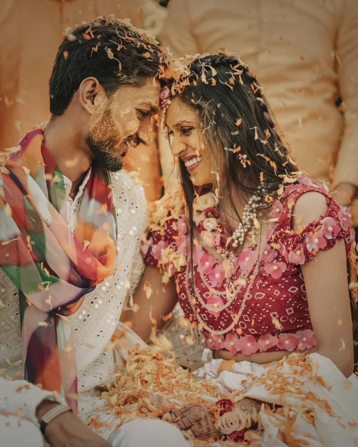 The couple laughing in a shower of petals