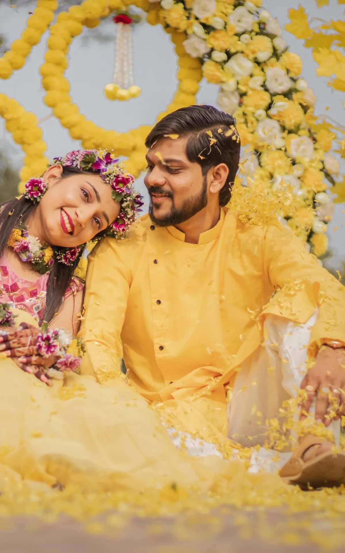 The bride resting her head on the groom's shoulder among yellow petals
