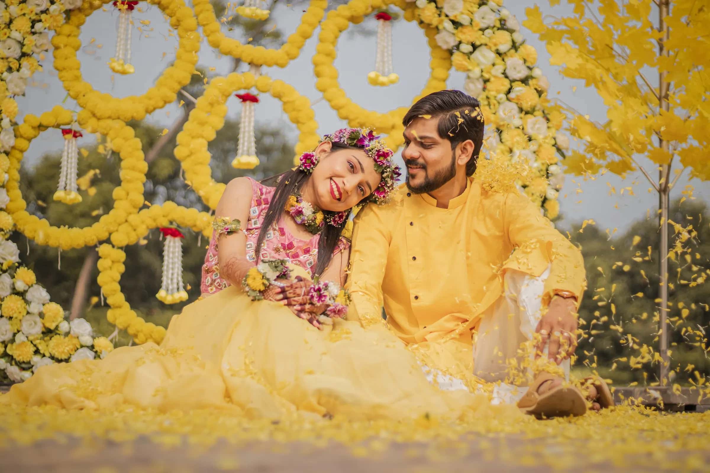 The bride resting her head on the groom's shoulder in a shower of petals