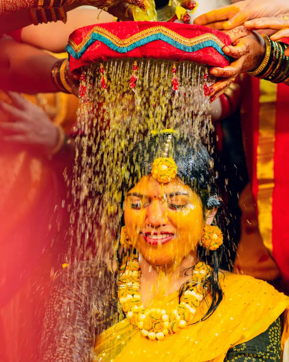 Turmeric water poured over the laughing bride