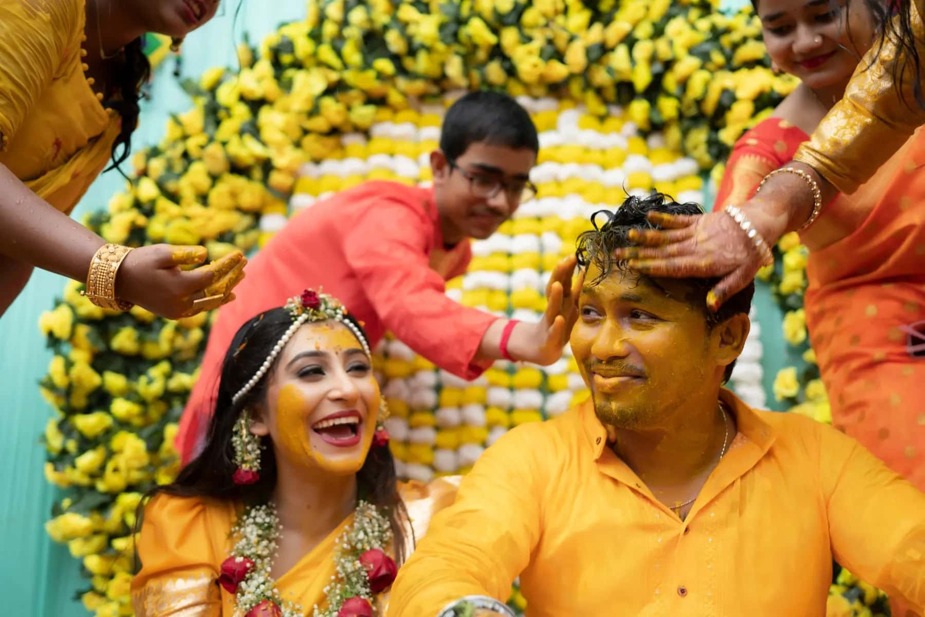 The family putting turmeric on the couple